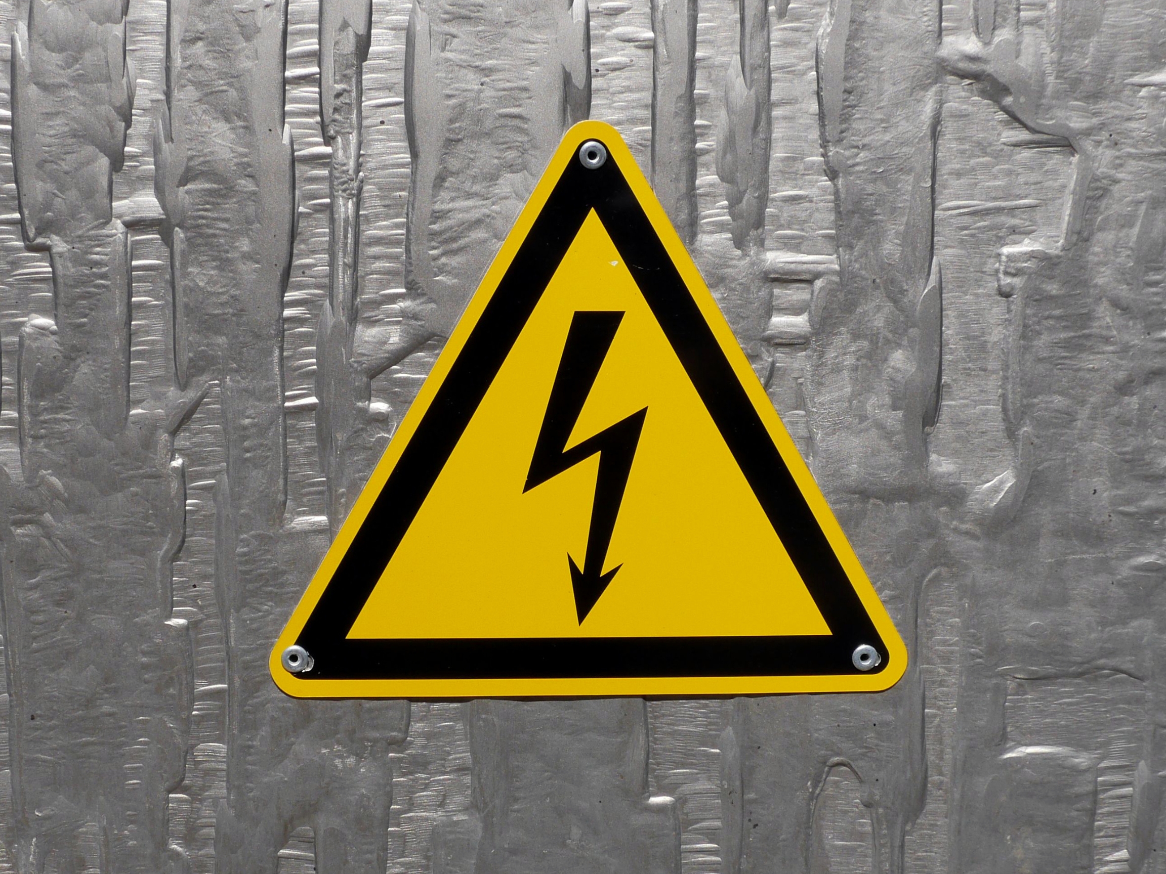 Header image displays voltage warning sign on a metal wall